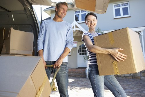 Movers carrying furniture in a Swisscottage apartment building